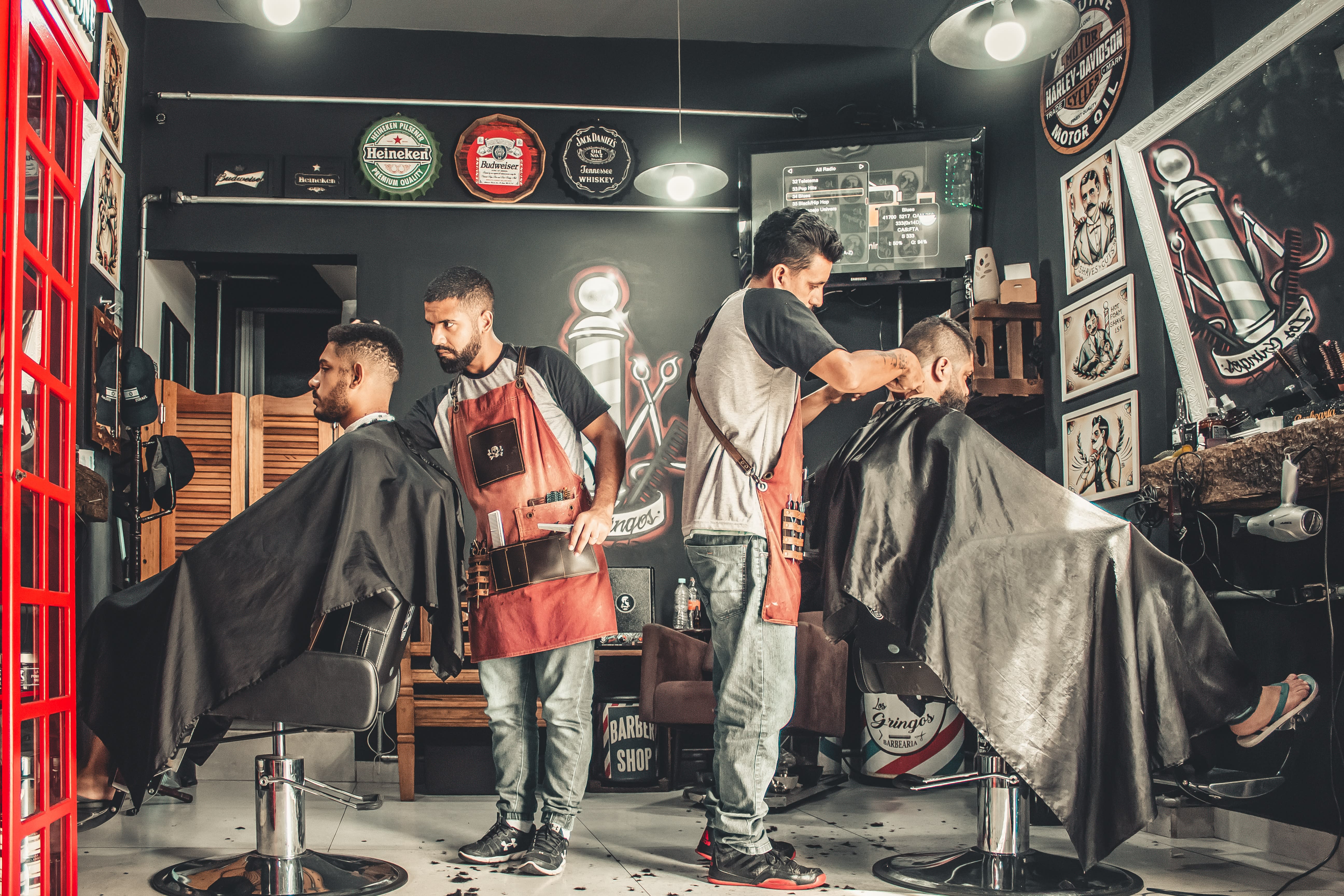 Photo of a barbershop with two barbers at work on their clients